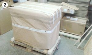 large item wrapped in brown paper and strapped securely on pallet
